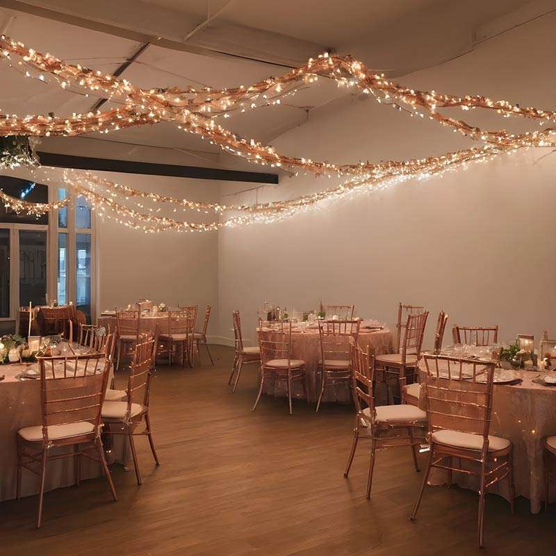 LED-copper-wire-fairy-lights-wrapped-around-chairs-at-an-indoor-wedding