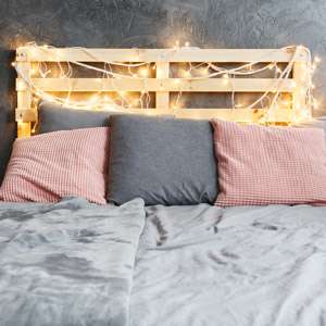 Cozy dreamy bed with decorated DIY pallet headboard