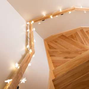 Cozy lights decorating wooden staircase. Home interior.