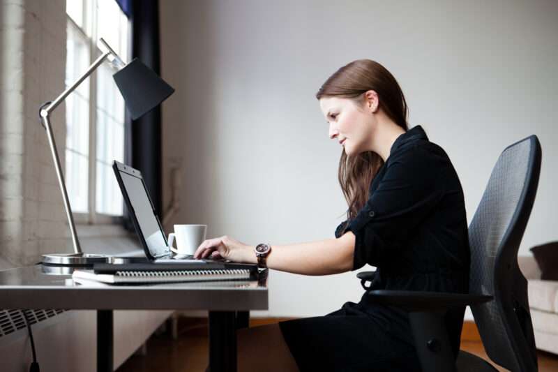 A young businesswoman in an office working on a laptop computer.